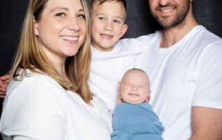 a family of for in. Matching white T-shirt s with a baby in blue