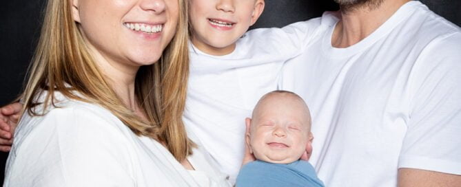 a family of for in. Matching white T-shirt s with a baby in blue