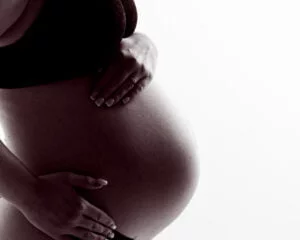 A pregnant belly in a black and white image against a white background