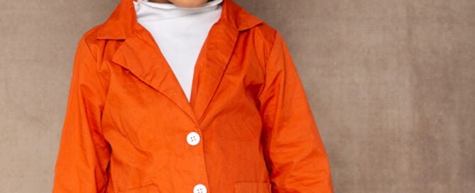 a young girl poses in an orange outfit