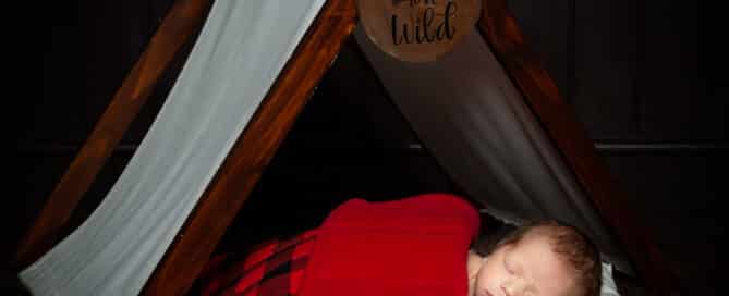 a newborn sleeping in my happy camper tent themed prop set