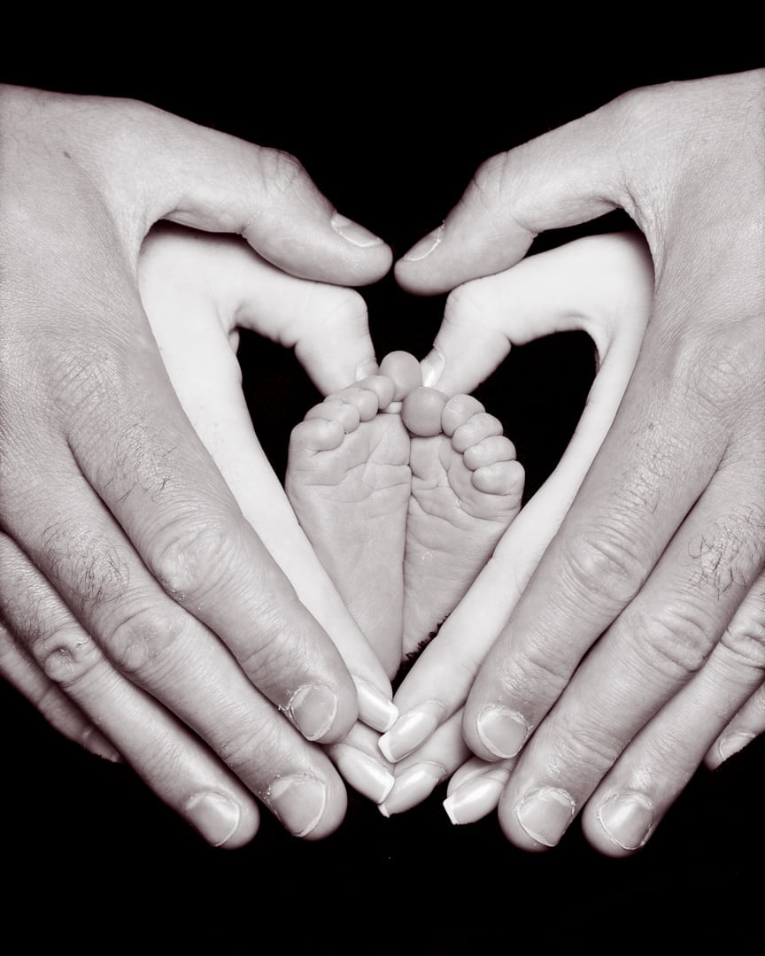 newborn feet framed in their parents hands