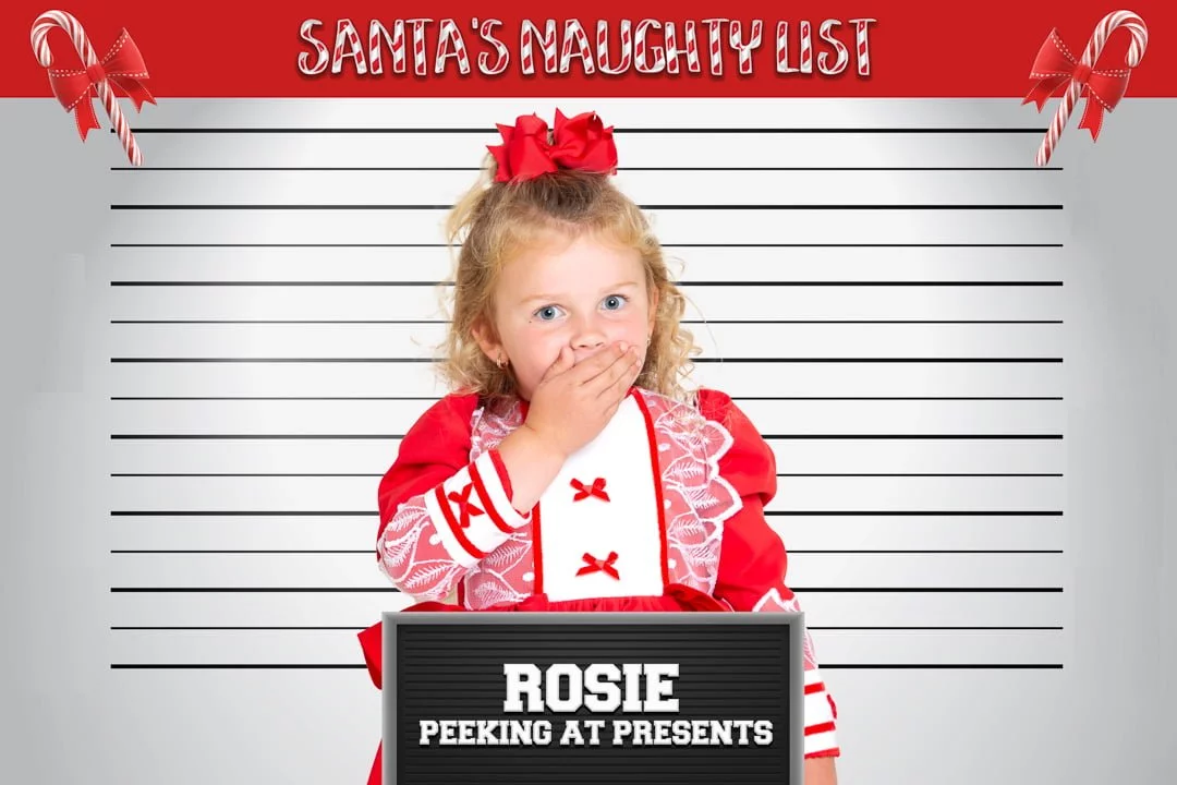 a little girl standing in front a mug shot board in a christmas themed photo