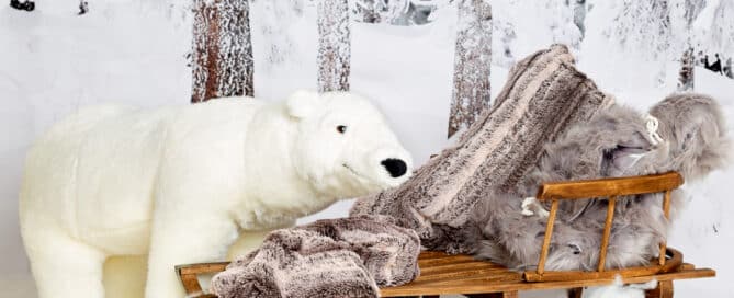 a snow themed christmas photo shoot set with a giant polar bear toy and wood sledge