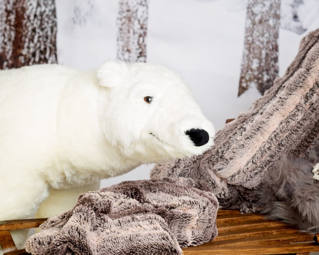 a friendly looking giant polar bear toy smiles for the camera
