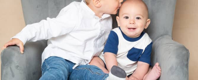 a big brother giving a kiss to his little brother