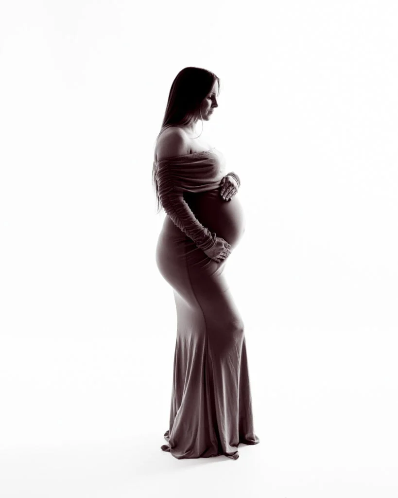 a black and white silhouette of a pregnant woman in a fitted dress