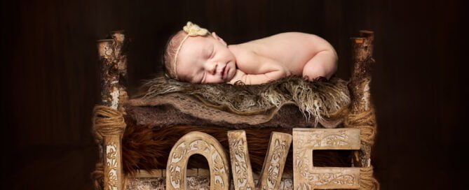 a newborn sleeping on a dark wood bed - digitally composited