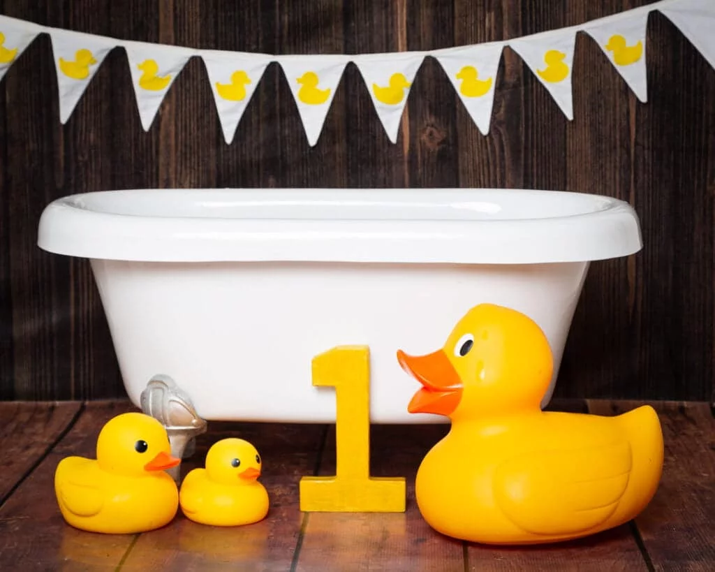 A white tub against a dark wood backdrop at a first birthday photo shoot