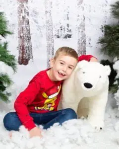 Christmas Photo Shoots West Sussex 2023 a little boy hugs a giant polar bear toy at a mini Christmas session