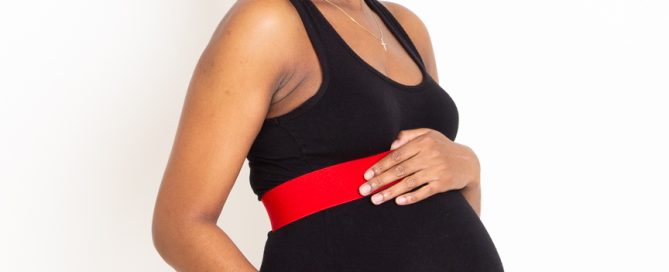 an elegant maternity photo taken in my studio of a woman in a black dress