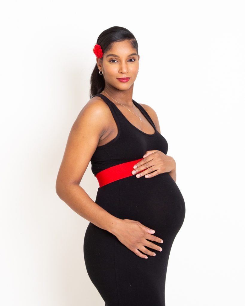 an elegant maternity photo taken in my studio of a woman in a black dress