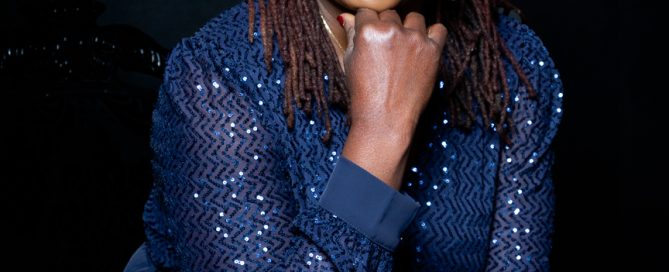 a glamorous woman poses in a navy sparkly outfit