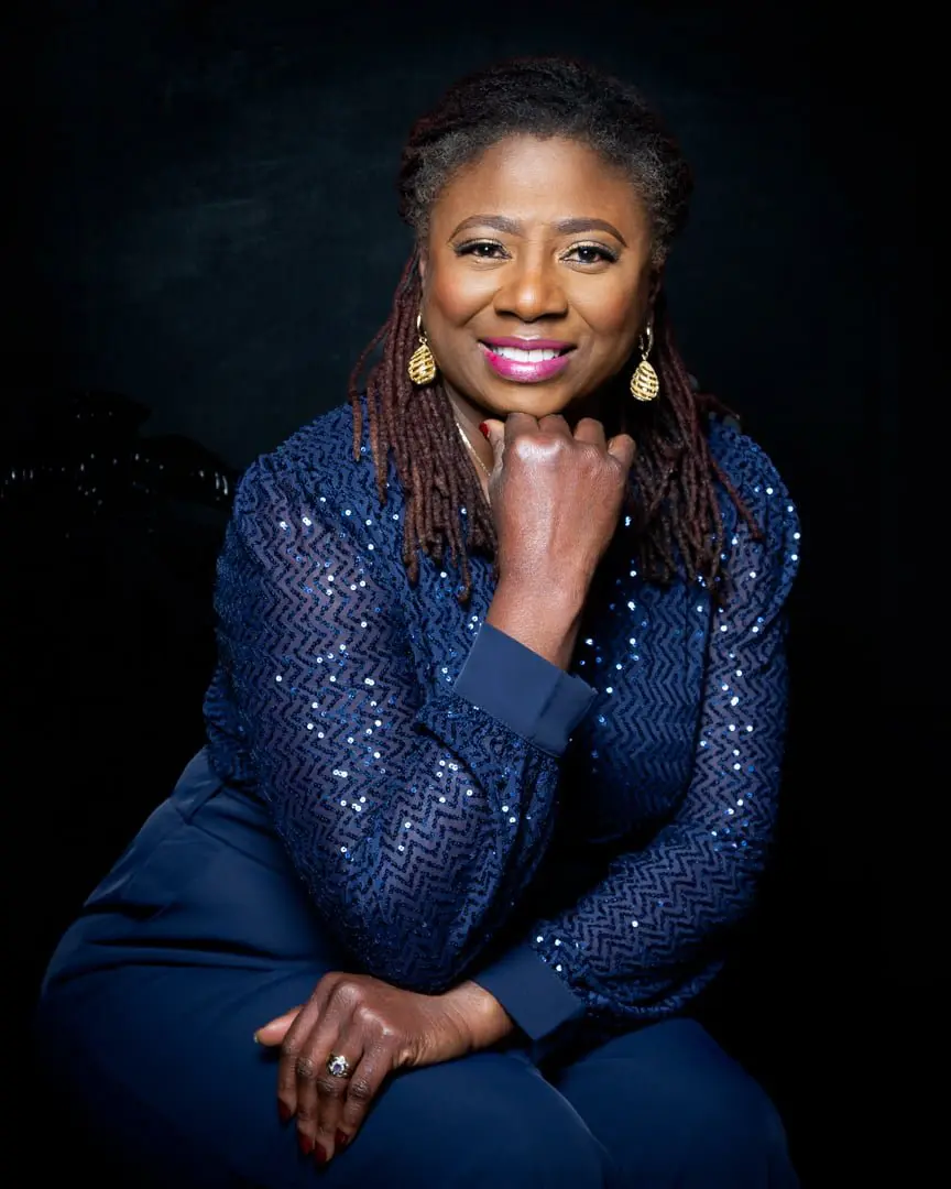 a glamorous woman poses in a navy sparkly outfit
