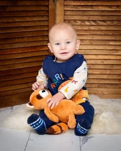 a baby and a red panda stuffed toy