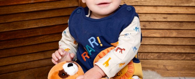 a baby and a red panda stuffed toy