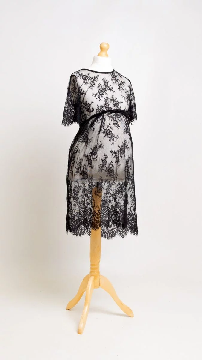 a black lace maternity dress on a mannequin