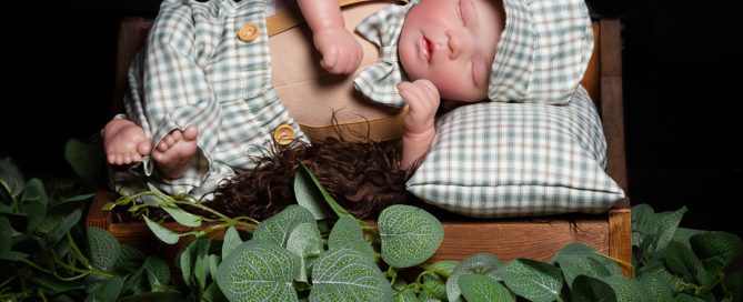 my dark wooden miniature prop bed styled with a newborn doll