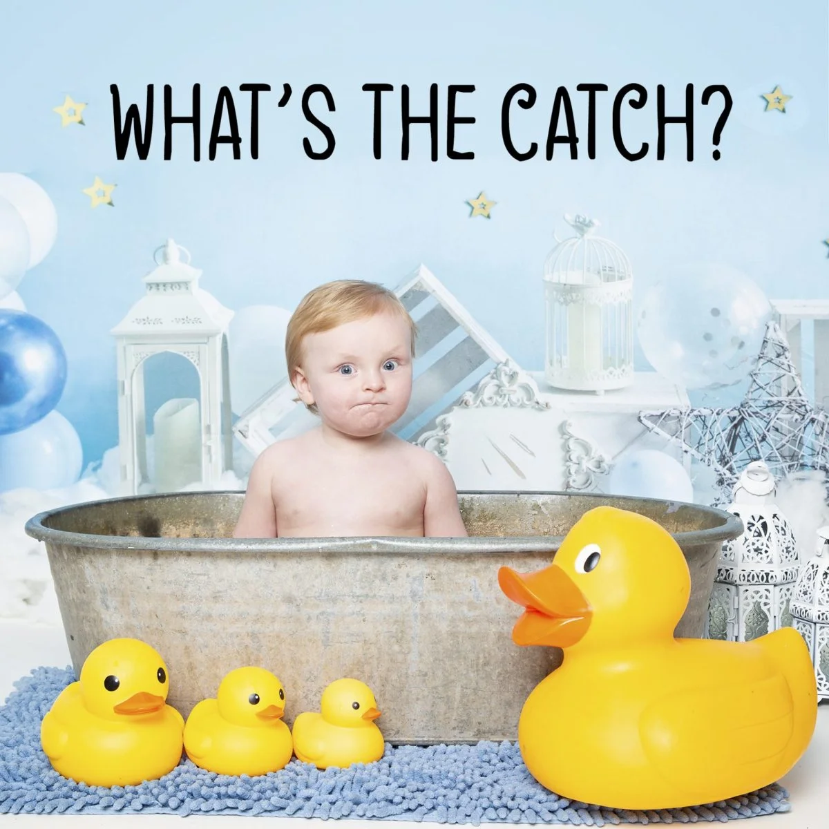 a little boy pulling a confused face in a tin tub surrounded by yellow rubber ducks