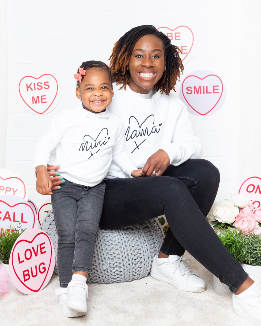 A mother and daughter pose in a love heart themed mother's Day set