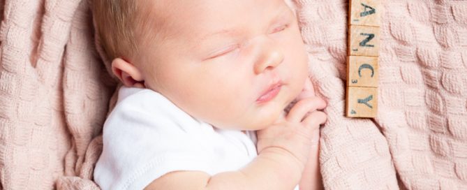 a newborn with a name plate that reads nancy