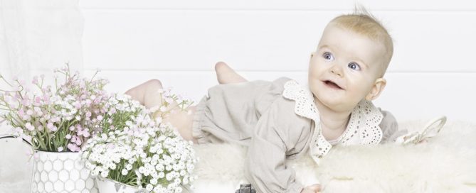 a baby in a cream outfit on my vintage suitcase prop