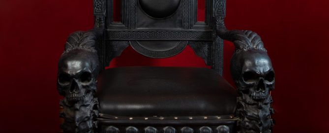 a gothic black skull throne against a red background in my photographic studio