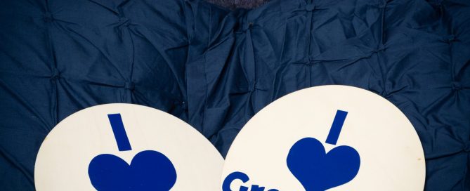 a navy bed and backdrop with two wooden signs saying I love daddy and I love Granddad