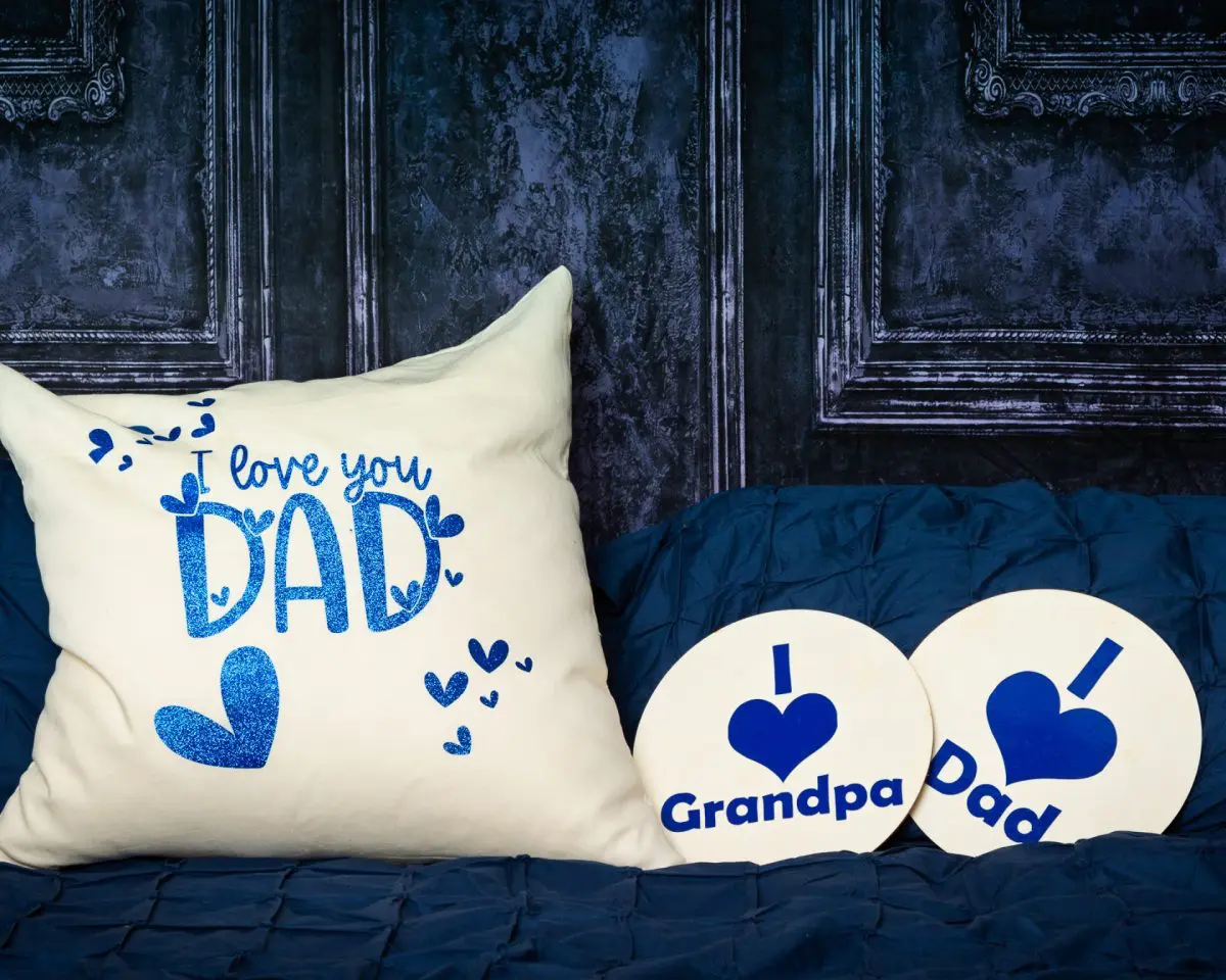 a navy bed and backdrop with a large cushion that says I love Dad