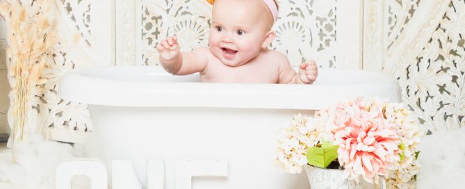 a little girl in a bathtub with a boho styled backdrop