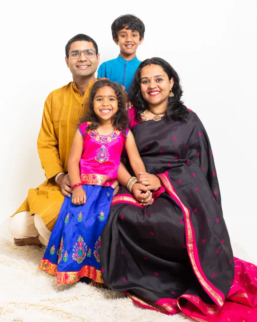 a family in traditional indian dress pose in the studio for a portrait