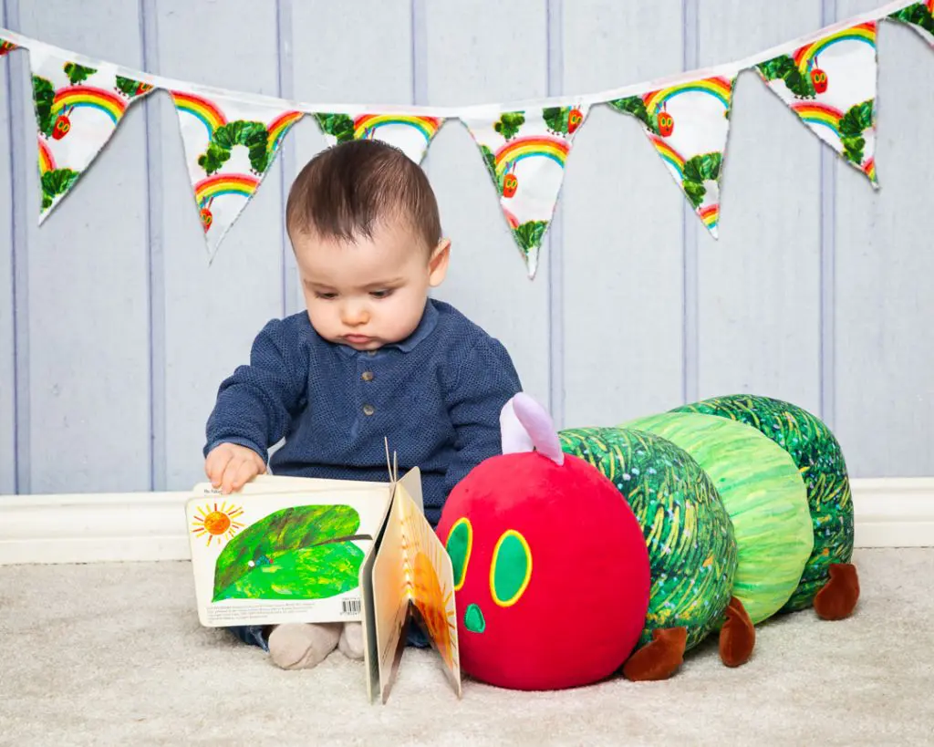 a little boy is reading the very hungry caterpillar