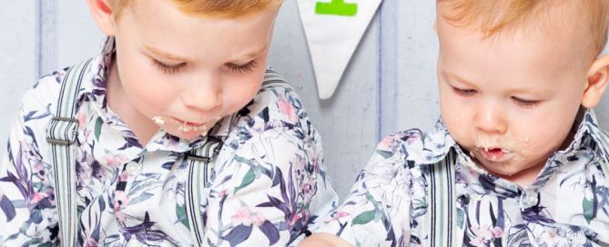 siblings sitting together at a cake smash photo shoot 1