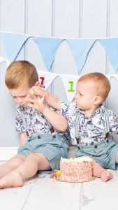 siblings sitting together at a cake smash photo shoot 3