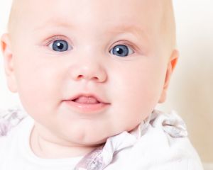 a close up of a baby's face at a professional photo shoot