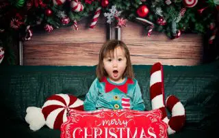 a little girl dressed as an elf at a christmas themed photo shoot