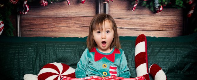 a little girl dressed as an elf at a christmas themed photo shoot