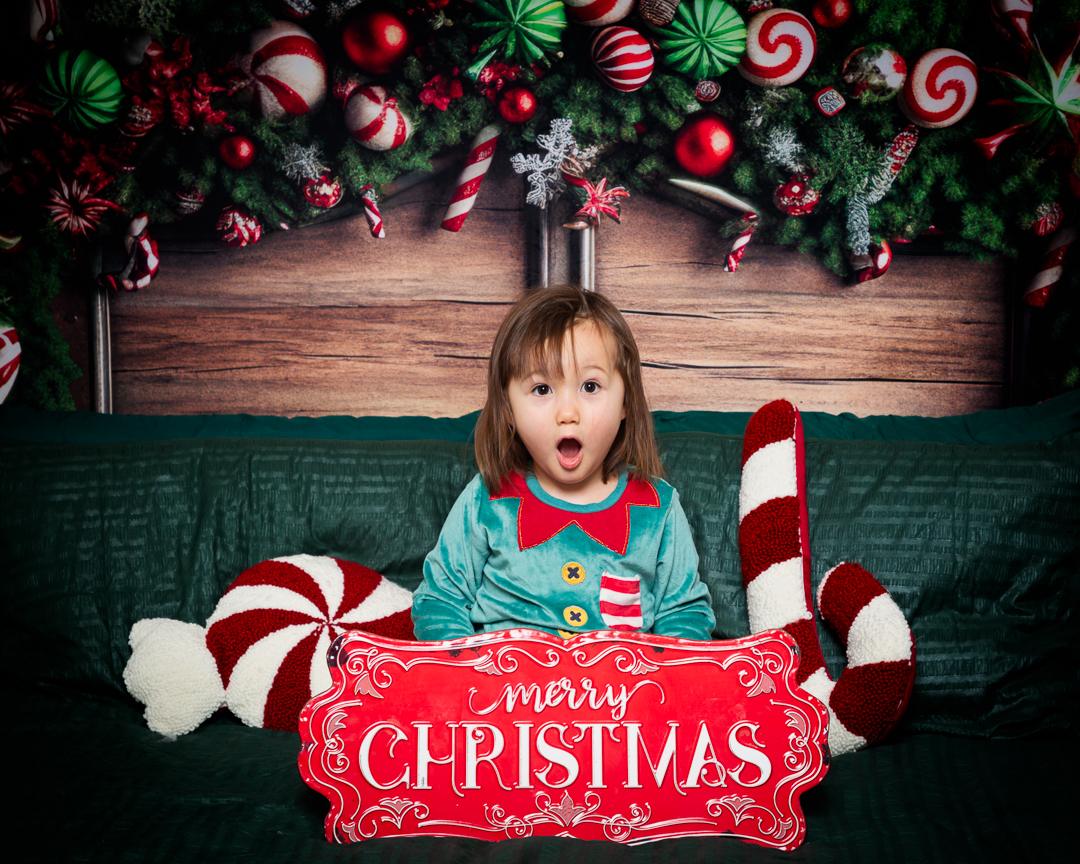 a little girl dressed as an elf at a christmas themed photo shoot