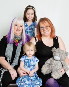 a family of three generations of women pose together for a family portrait
