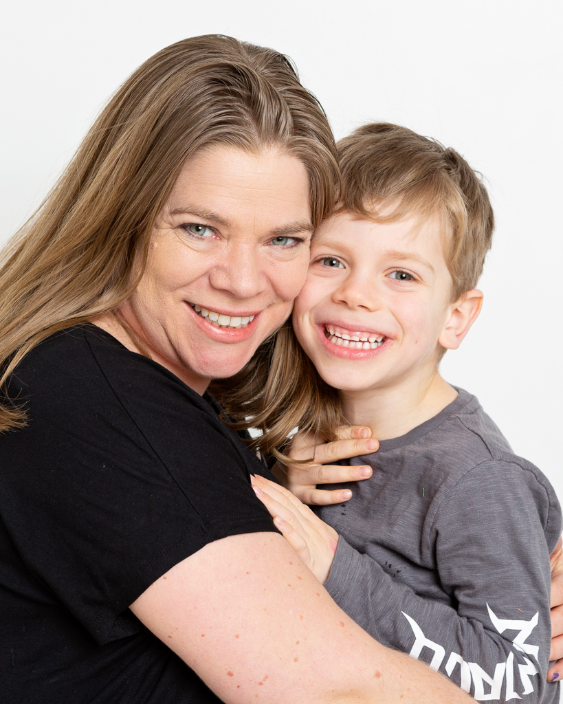 a mum cuddles her son at a family photo shoot