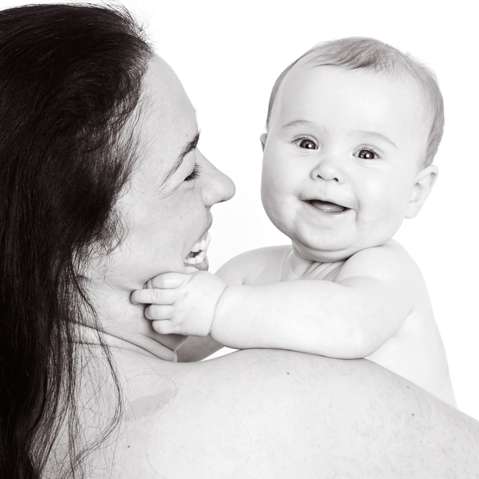 a mum poses with her baby daughter on her shoulder