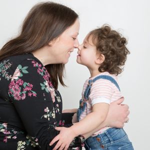 a mum and her young daughter pose nose to nose for a professional photoshoot