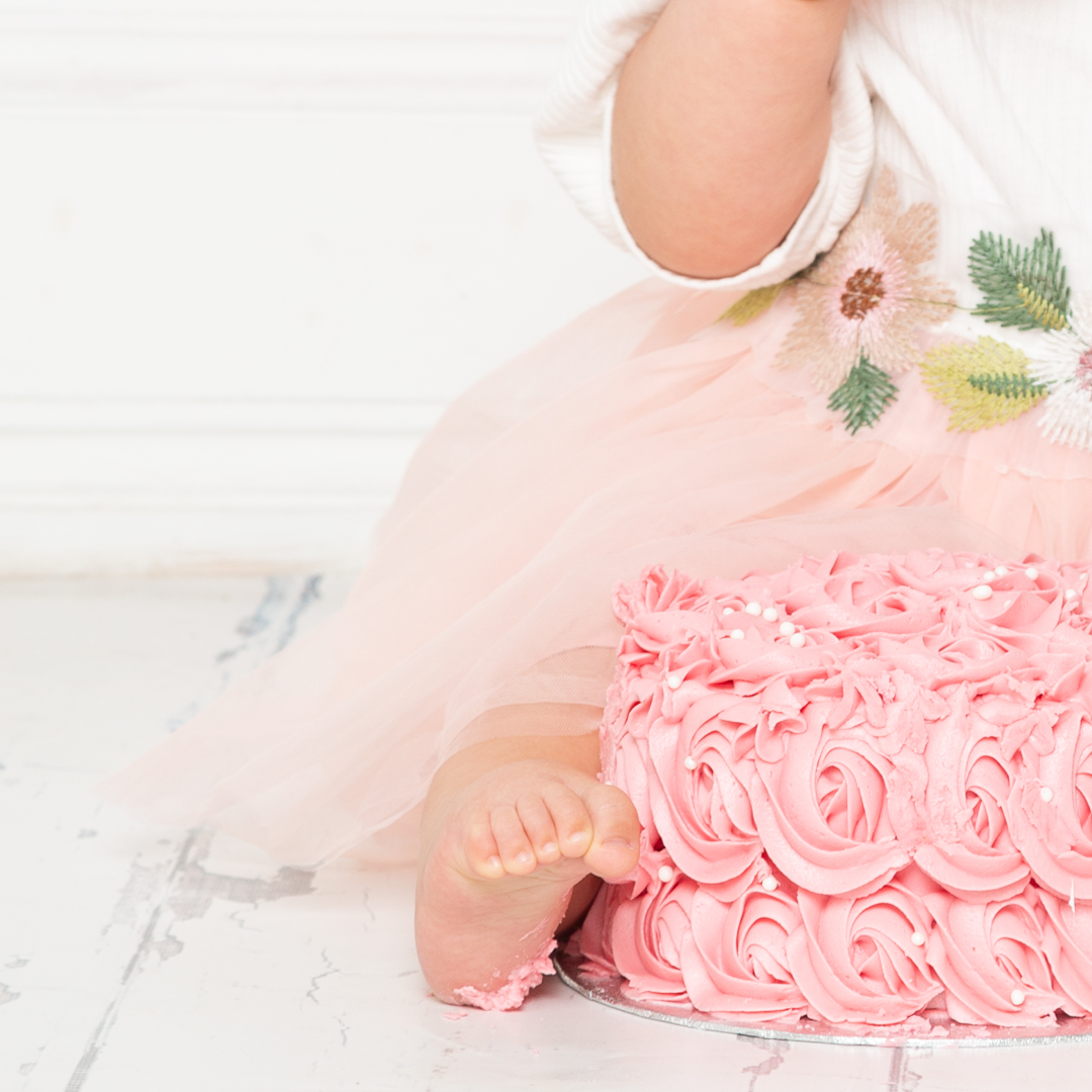 a baby's feet covered in icing at a cake smash photo shoot