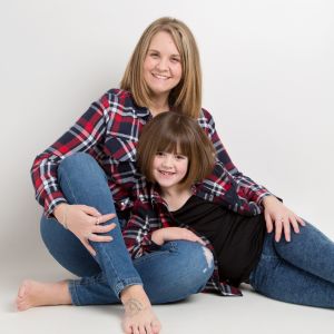 a mum and young daughter pose in matching shirts for aprofessional photoshoot