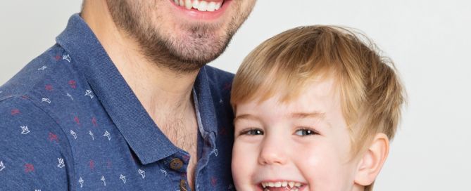 A dad cuddles his son in a profession family photo shoot