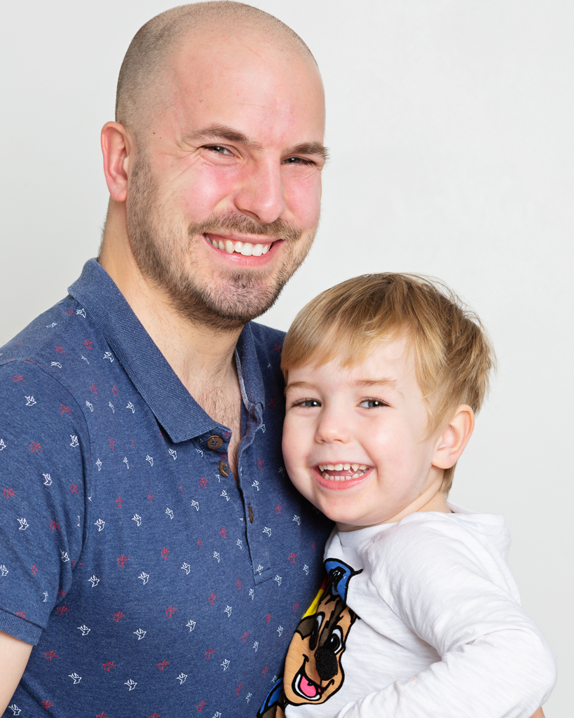 A dad cuddles his son in a profession family photo shoot