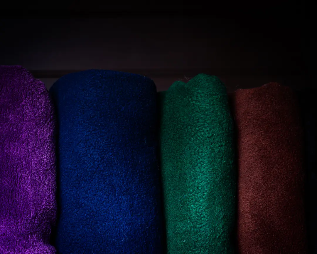 a range of jewel toned blankets stacked together