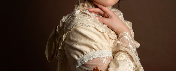a girl poses in a lace vintage style dress for a fine art portrait