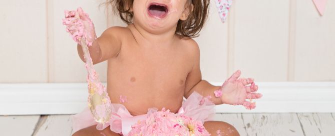 a little girl crying dramatically by her cake