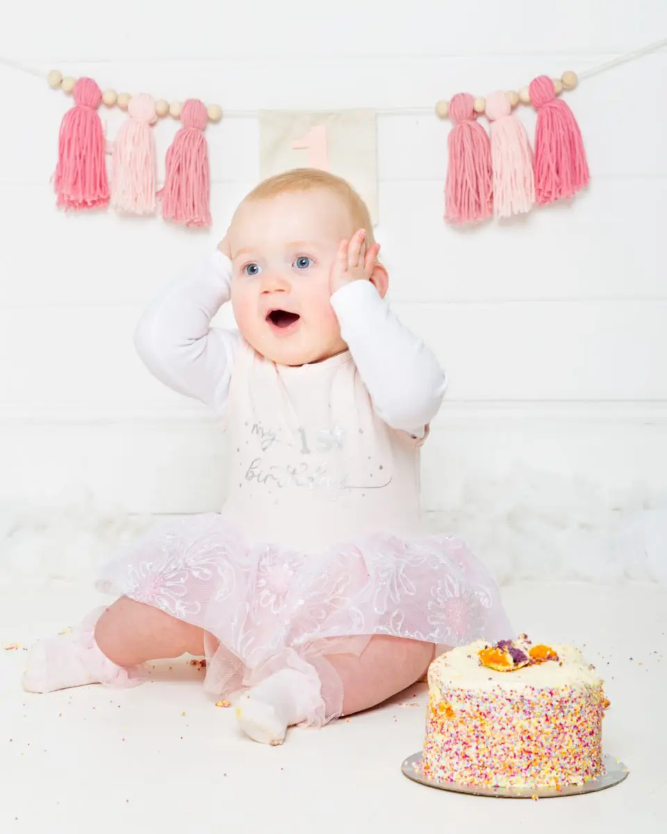 a little girl looking amazed that she gets whole cake